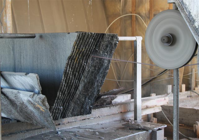 Sawing up slabs a granite a diamond rope in shop of machine tools for sawing blocks.  =>Following
