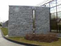 Фасад здания выложенный облицовочными плитами с фактурой «скала» из серого гранита